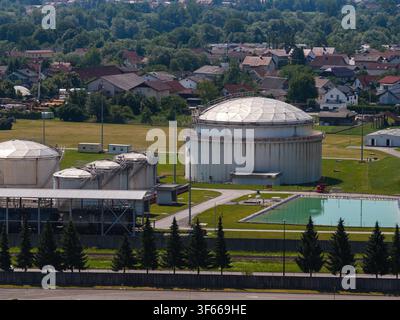 Speichertanks für Öl sind aus der Luft in der Nähe eines Wohngebiets mit Grünflächen um sie herum zu sehen. Stockfoto