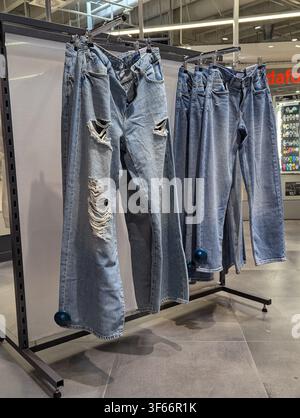 Hängende, Used-Look-Blaujeans an einem Einzelhandels-Kleiderständer in einem modernen Ladenbereich Stockfoto