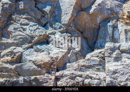 Nahaufnahme einer zerklüfteten vulkanischen Felsformation mit verwitterter Klippenoberfläche unter hellem Sonnenlicht. Gran Canaria. Spanien. Stockfoto