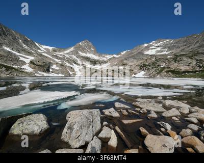 Schneeschmelzbach stürzt über Granitblöcke entlang des Mitchell Lake Trails, Indian Peaks Wilderness, Colorado, USA, Ende Juni. Stockfoto