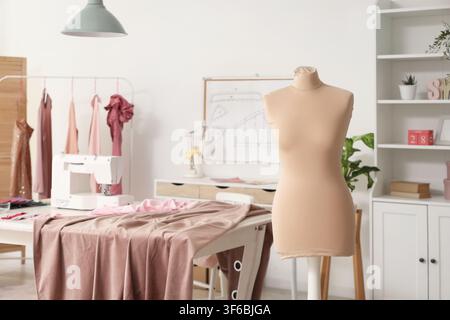 Schneidersarbeitsplatz mit Mannequin in einem stilvollen Atelier Stockfoto