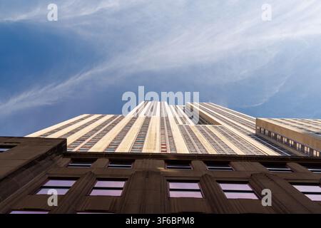 New York, USA - 03. November 2024: Blick von unten auf das Empire State Building vor blauem Himmel Stockfoto