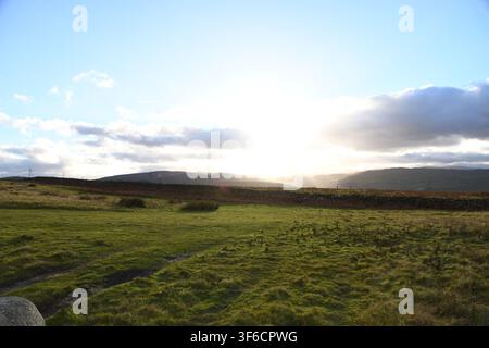 Die Sonne bricht durch die Wolken über der hügeligen grünen Landschaft im Lake District, Cumbria Stockfoto