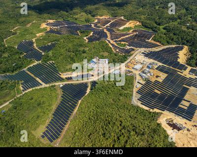Luftbild des Sikatuna-Solarkraftwerks mit weitläufigen Solarpanel-Arrays, die über das hügelige, bewaldete Gelände von Sikatuna im zentralen Visa installiert sind Stockfoto
