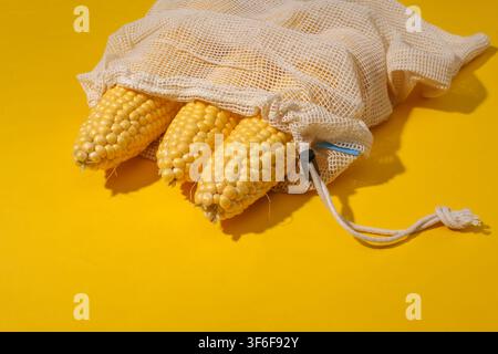 Maiswipfel in einem Öko-Baumwollbeutel auf gelbem hellem Hintergrund. Stockfoto