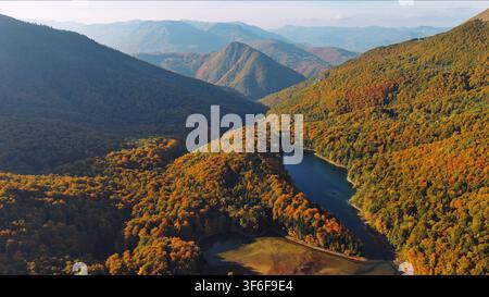 Winding Fluss durch ein Bergtal mit Herbstwald Stockfoto