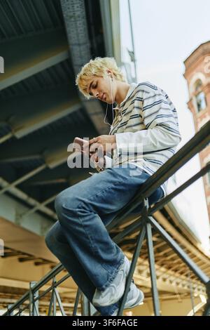 Mann, der im Freien Musik auf einem Smartphone hört Stockfoto