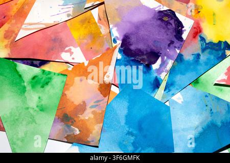 Dreiecksgeschnittenes Papier mit Farbspritzern abstrakter Regenbogenhintergrund Malerei kreative Formen Stockfoto