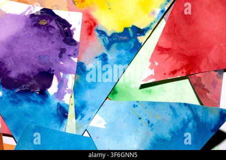Dreiecksgeschnittenes Papier mit Farbspritzern abstrakter Regenbogenhintergrund Malerei kreative Formen Stockfoto