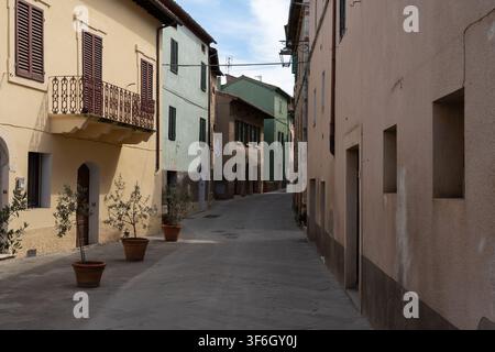 Malerische enge Straße mit traditionellen pastellfarbenen Fassaden im historischen Dorf Castiglione d'Orcia, Toskana, Italien Stockfoto
