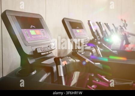 Cardio-Zone mit Trainingsgeräten in einem sonnendurchfluteten Fitnessstudio, selektive Schärfentiefe Stockfoto