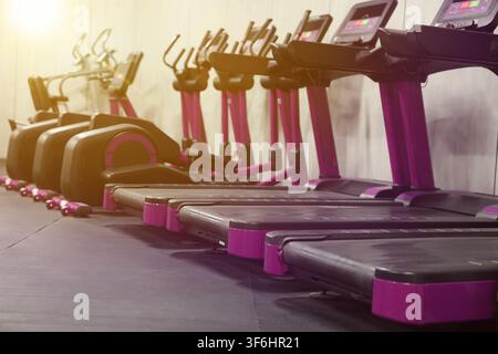 Cardio-Zone mit Laufbändern in einem sonnendurchfluteten Fitnessstudio, selektive Schärfe Stockfoto