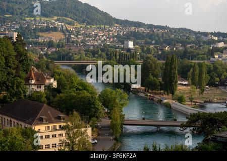 Bern, Schweiz - 28. Juni 2026: Eine weitläufige Landschaftsaufnahme der Aare, die Bern, Schweiz, durchschneidet, umgeben von lebhaft grünen Bäumen Stockfoto