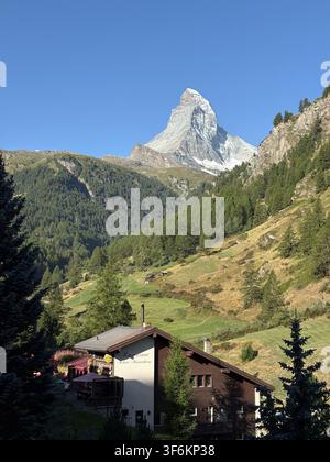Majestätischer Blick auf den ikonischen Matterhorn-Gipfel und ein traditionelles Schweizer Chalet in Zermatt, Schweiz Stockfoto