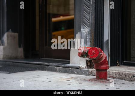 Rote Feuerschance auf dem Gehweg in der Nähe des Gebäudeeingangs Stockfoto
