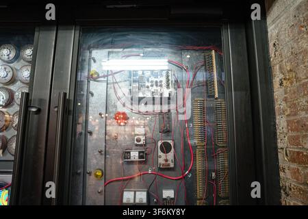 Vintage-Elektriksteuerung mit Kabeln und Messgeräten hinter Glas Stockfoto