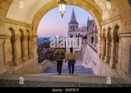 Budapest, Ungarn, bietet eine romantische Szene, während ein Paar Hand in Hand durch die Fischerbastei bei Sonnenuntergang schlendert. Stockfoto