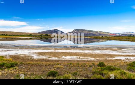 Scenische Ansicht eines Gebirgszugs, der sich in den ruhigen Gewässern des Alkali Lake in der Nähe von Cody, Wyoming, spiegelt Stockfoto