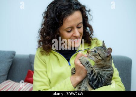 Frau hält eine Hauskatze und zeigt Glück und Verbindung mit ihrem Haustier Stockfoto