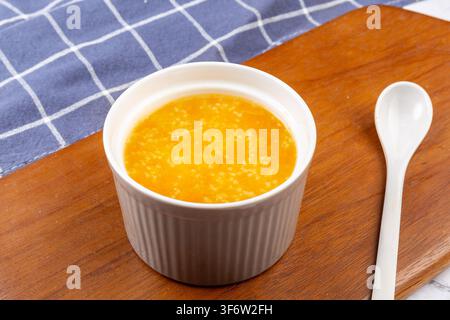 Goldener Hirse-Kürbisbrei garniert mit getrockneten Goji-Beeren Stockfoto