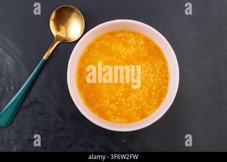 Goldener Hirse-Kürbisbrei garniert mit getrockneten Goji-Beeren Stockfoto