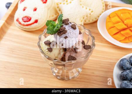 Verschiedene Eisbecher mit Kekskrümeln und Minze oben drauf Stockfoto