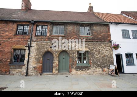 Historische Stein- und Backsteinhäuser mit spitzbogigen Türen und Holzfensterrahmen am Castle Square in der Altstadt von Lincoln, UK. Stockfoto
