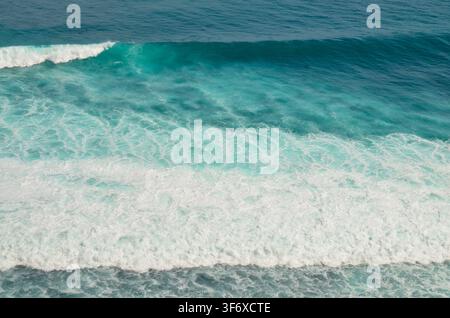Dramatischer Nahaufnahme einer mächtigen blauen Meereswelle, die bei sonnigem Tageslicht mit Wasserspritzern zuschlägt Stockfoto