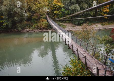 Lange Hängebrücke, die einen Fluss im Herbst überquert Stockfoto