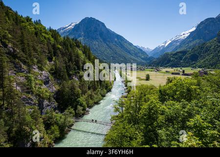 Aareschlucht, Schweiz, 23. Mai 2026. Hochwinkelaufnahme, die vom Eingang der Schlucht aus über den türkisfarbenen Aare-Fluss, eine Hängebrücke, Grün blickt Stockfoto