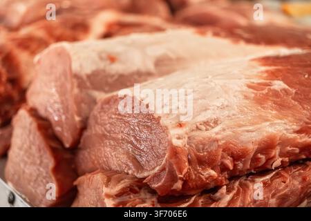Nahaufnahme von unverarbeiteter Schweinefleischscheibe, die zum Verkauf in einem Laden arrangiert ist und einen detaillierten Blick auf die Muskelfasern und das Fett für professionelle Lebensmittel bietet Stockfoto