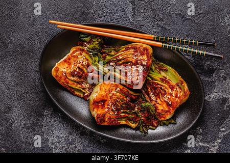 Gekochter Kohl Bok Choy auf einem Teller mit Gewürzen und Kräutern serviert, Ansicht von oben. Stockfoto