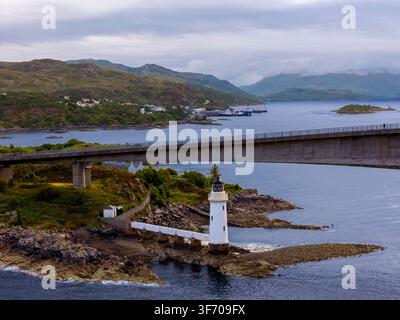 Luftbild-Drohnenaufnahme des Kyleakin-Leuchtturms neben der Skye-Brücke auf der Isle of Skye, Schottland, mit Blick auf die Küstengewässer. Stockfoto