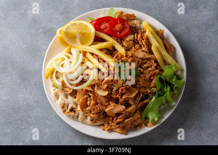 Oberansicht eines traditionellen türkischen Hähnchen-Doner-Kapselgerichts mit Pommes frites und Salat oder griechischem Gyros Stockfoto