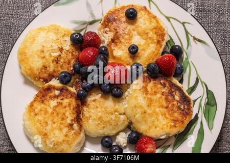 Traditionelle osteuropäische Syrniki-Käse-Pfannkuchen mit frischen Beeren Stockfoto