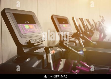 Cardio-Zone mit Trainingsgeräten in einem sonnendurchfluteten Fitnessstudio, selektive Schärfentiefe Stockfoto