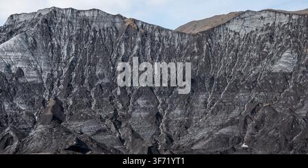 Nahaufnahme von Gletschereis, das gestreifte Muster aus dunkler Vulkanasche und hellem weißem Eis zeigt, Island. Stockfoto