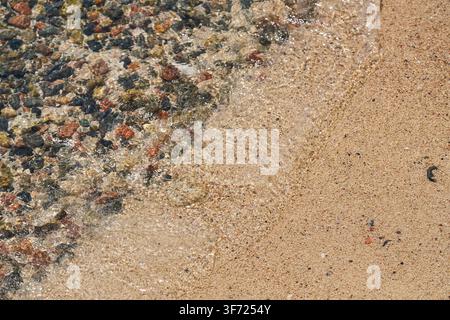 Sandstrand, Meerwasser spült darüber, Nahaufnahme-Detail - abstrakter tropischer Urlaubs-Hintergrund Stockfoto
