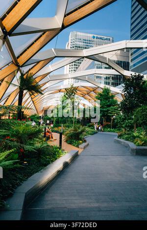 Besucher genießen den üppigen Crossrail Place Roof Garden im Canary Wharf, einem ruhigen öffentlichen Rückzugsort im geschäftigen Finanzdistrikt von London. Stockfoto