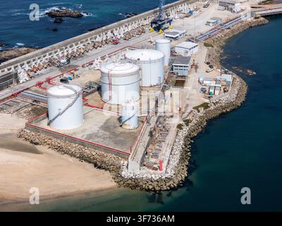 Luftbild von LNG-Silos, die an der Küste mit industrieller Infrastruktur, Lagertanks und felsigen Wellenbrechern in Matosinhos, Porto, Portugal gelegen sind Stockfoto