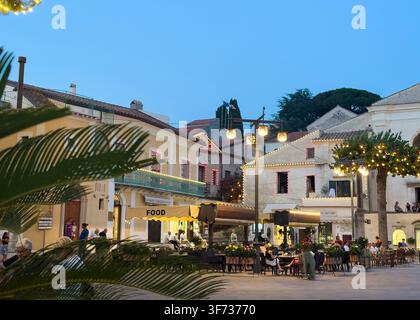 Piazza Duomo von Ravello mit Restaurants und historischen Gebäuden, die bei Abenddämmerung an einem Sommerabend beleuchtet sind, Amalfiküste, Kampanien, Italien. Stockfoto