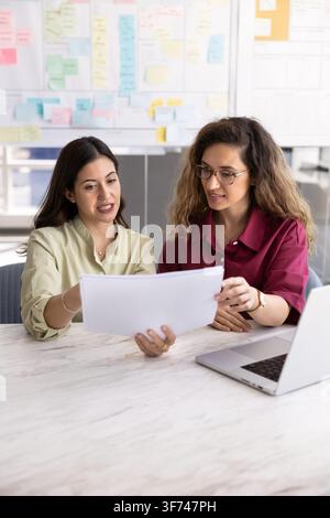 Geschäftsfrauen, die Geschäftsdokumente am Schreibtisch im Firmenbüro durchsehen Stockfoto