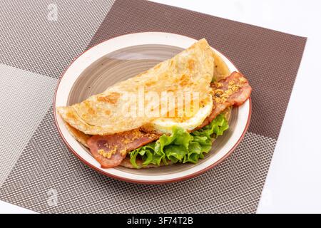 Knuspriger Frühlingszwiebel-Pfannkuchen Wrap mit gebratenem Schinkenei und Schweinefloss Stockfoto