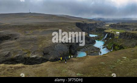 Luftperspektive eines tiefen Canyons, der durch dunkle Basaltformationen geschnitten ist, mit türkisfarbenen Gletscherschmelzwasserbächen. Stockfoto