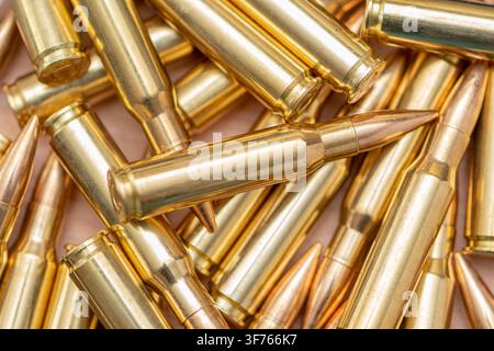 Eine Nahaufnahme zeigt einen verstreuten Haufen Messingpatronen und spitze Kugeln. Stockfoto