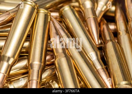 Eine Nahaufnahme zeigt einen Stapel metallischer Gewehrpatronen, die in einem engen Bildrahmen überlappen. Stockfoto