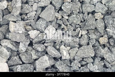 Nahaufnahme von feinem grauem Brecherstein mit kantigen Formen und gleichmäßiger Korngrößenverteilung. Verwendet für Betonmischungen, Straßenfundamente, Drainagesysteme Stockfoto