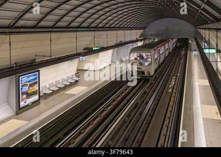 Lyon, Frankreich - 27. Juli 2026: Perspektivische Ansicht einer gewölbten unterirdischen U-Bahn-Station mit einem Zug, der sich leeren Sitzbänken auf der Plattform in Lyon nähert. Stockfoto