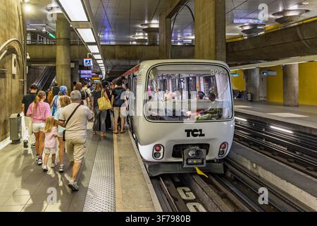 Lyon, Frankreich - 27. Juli 2026: Menschen warten und steigen in eine automatisierte fahrerlose Metro-Zug, der von TCL betrieben wird, auf einer unterirdischen Plattform ein. Stockfoto