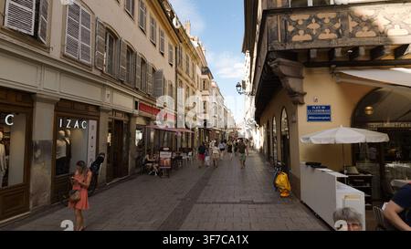 STRASBOURG, FRANKREICH - 6. AUGUST 2026 - Menschen schlendern eine belebte Einkaufsstraße in Straßburg, Frankreich, entlang, gesäumt von historischen Gebäuden Stockfoto